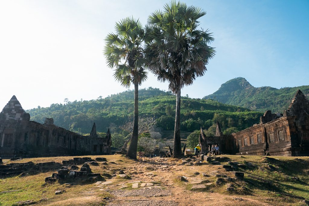 Old buildings, trees, and mountains in Laos.
