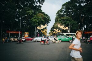 A boy crossing the street and the Saigon road with traffic.